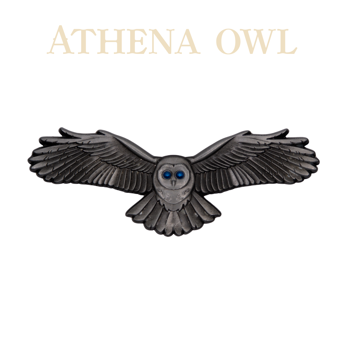 A three dimensional pin of an owl with it's arms outstretched and bright blue eyes