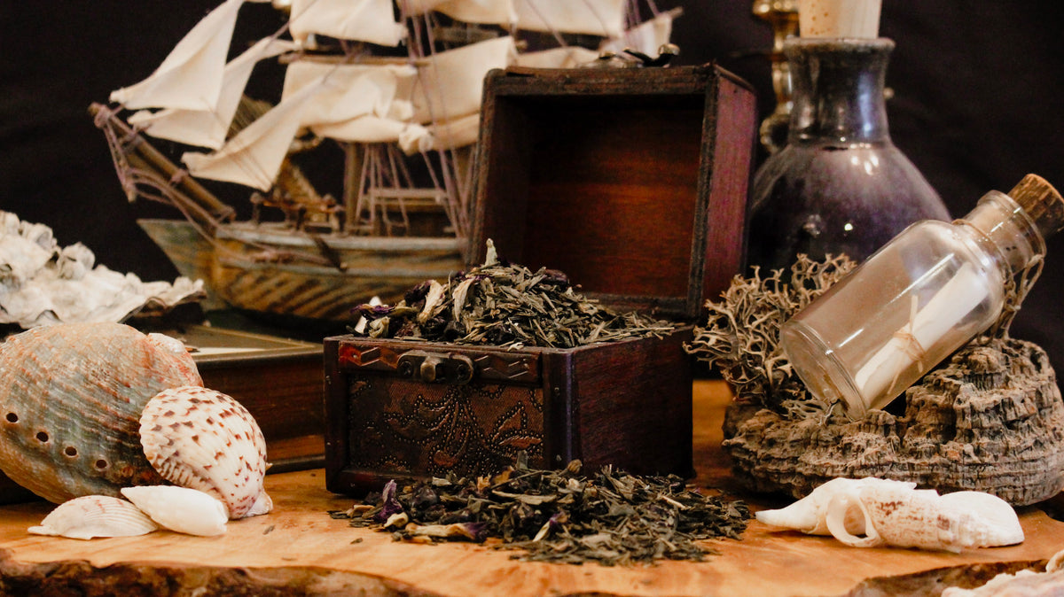 Decorative still life with a ship model, seashells, and a bottle on a wooden surface.